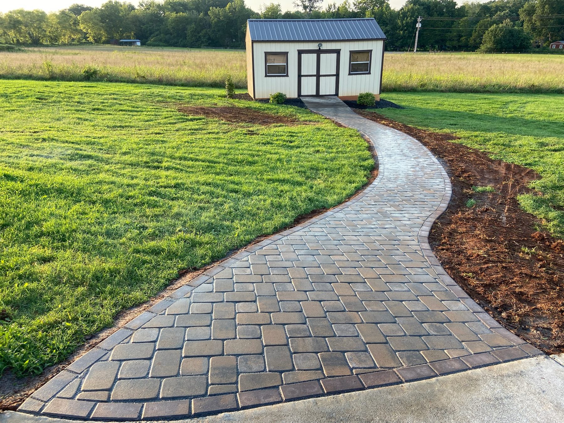Curved paver walkway with mulched planting beds